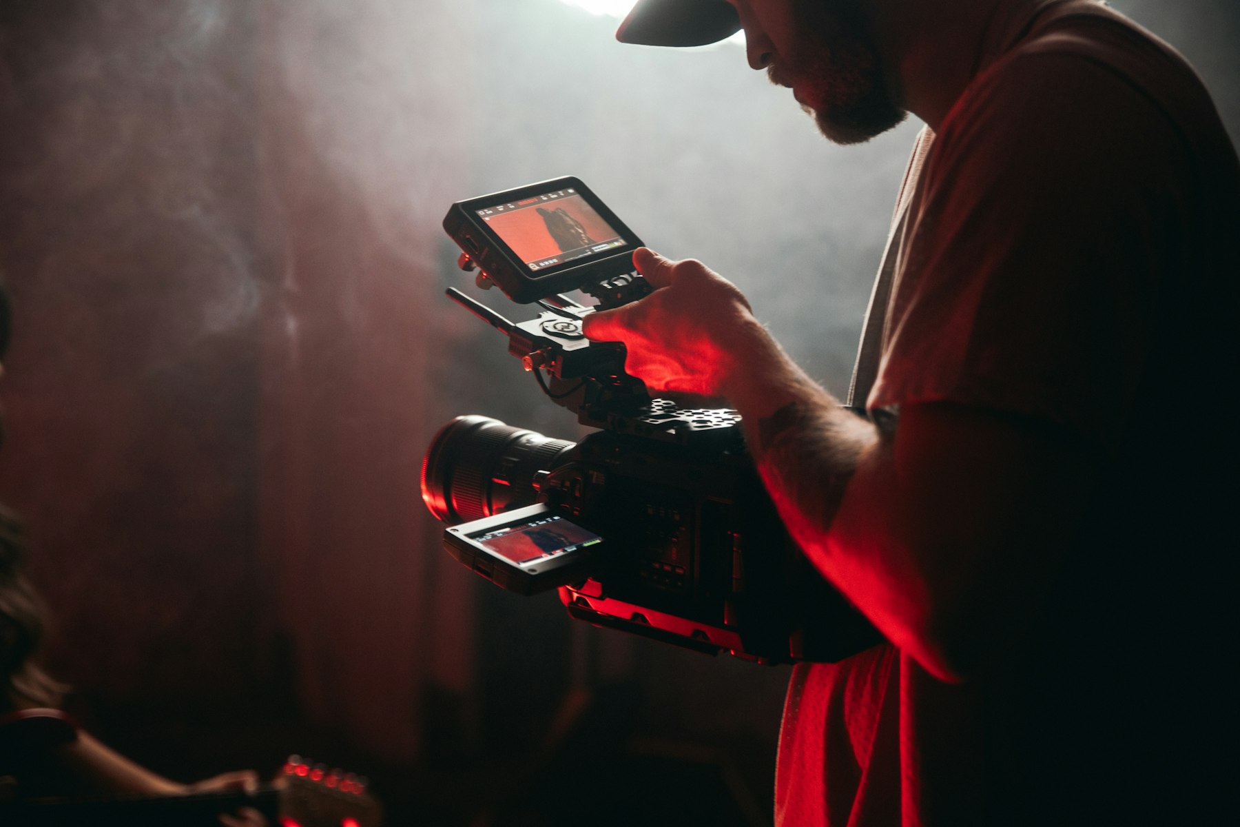 A camera operator checking a shot on a handheld monitor